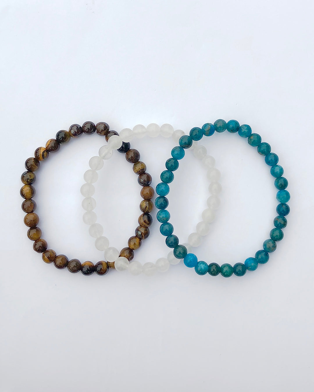 Apatite, Snow Quartz and Tiger Eye 6mm beaded Gemstone Bracelet Set for Courage and Truth on a white background.