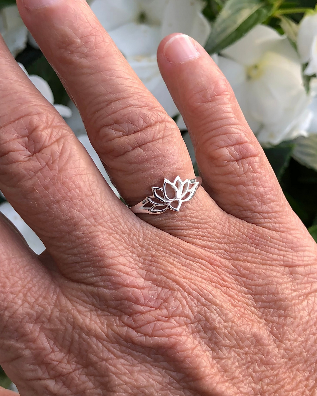 Sterling Silver Lotus Ring on right ring finger with white flowers in background