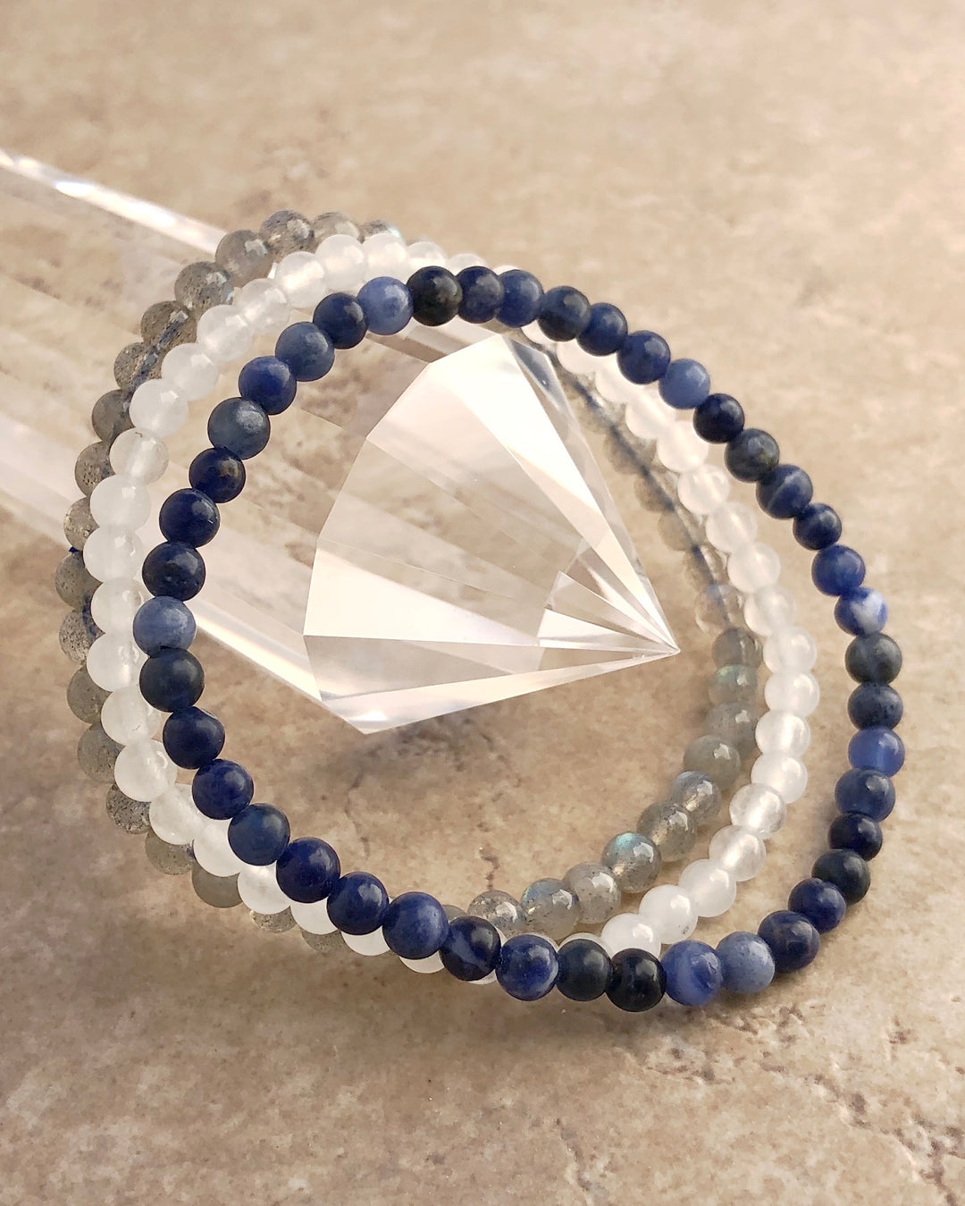 Divine Intuition 4mm Gemstone Bracelet Set with Labradorite, Snow Quartz and Lapis Lazuli on a crystal