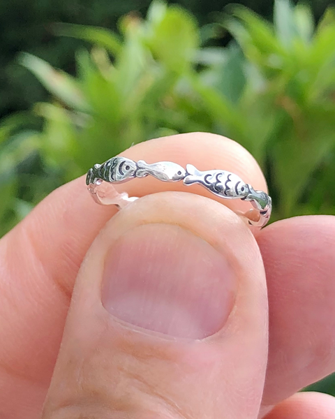Sterling Silver school of Fish Ring held between fingers