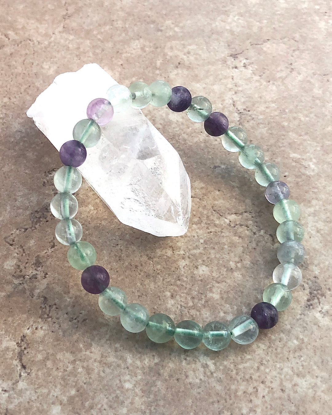 Fluorite 6mm Beaded Gemstone Bracelet on a crystal.