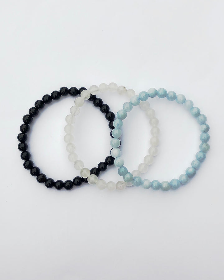 Aquamarine, Snow Quartz and Black Agate6mm beaded Gemstone Bracelet Set for Healing and Renewal on a white background.