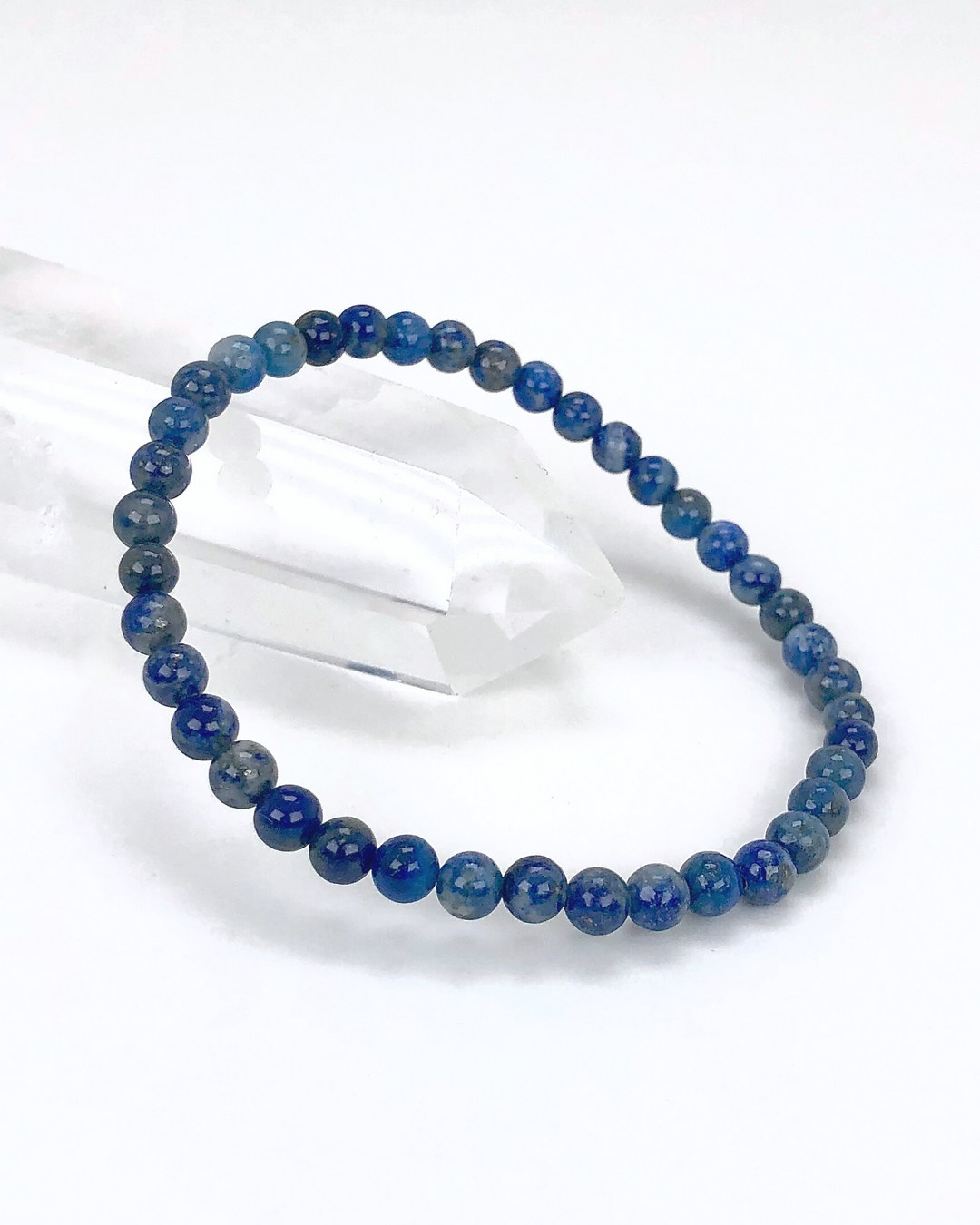 Lapis Lazuli 4mm Beaded Gemstone Bracelet on a crystal with a white background