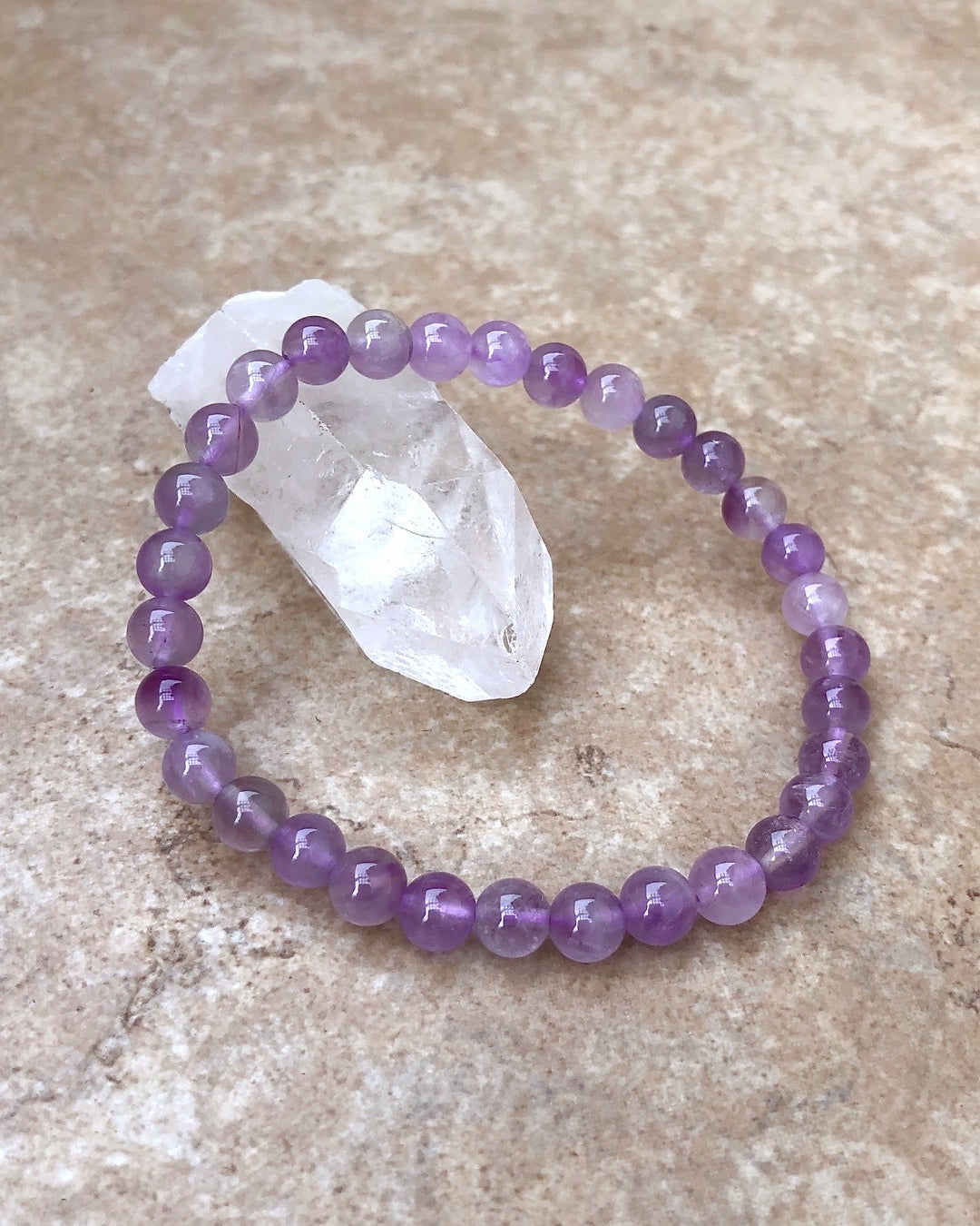 Lavender Amethyst 6mm Beaded Gemstone Bracelet on a crystal.