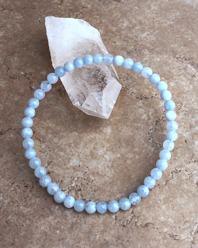 Men's Aquamarine 4mm Beaded Gemstone Bracelet on a crystal