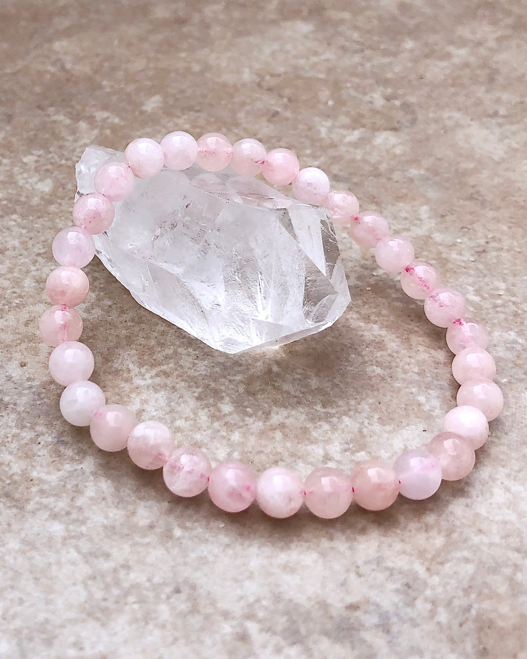 Moonstone 6mm Beaded Gemstone Bracelet on a crystal.