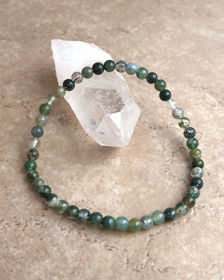 Moss Agate 4mm Beaded Gemstone Bracelet on a crystal.