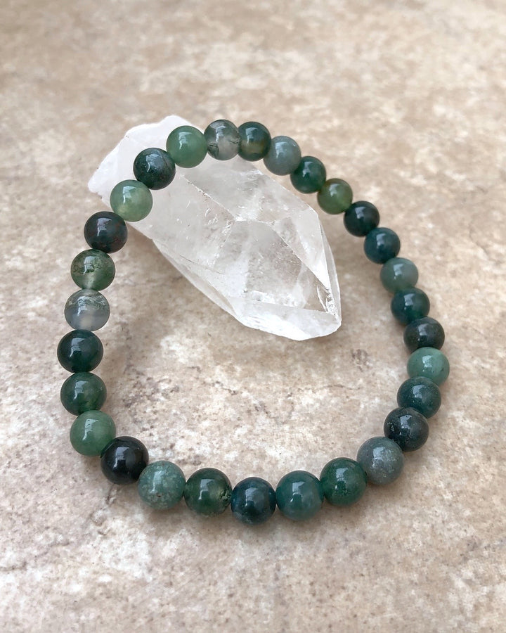 Moss Agate 6mm Beaded Gemstone Bracelet on a crystal.