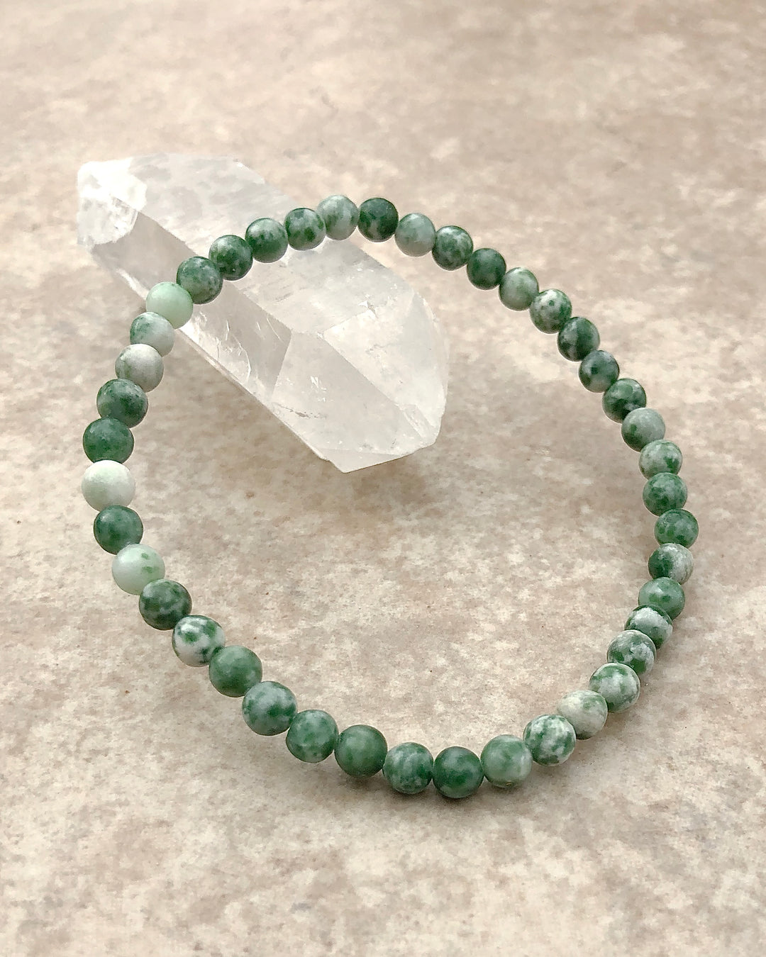 Natural Green Jade 4mm Beaded Gemstone Bracelet on a crystal.