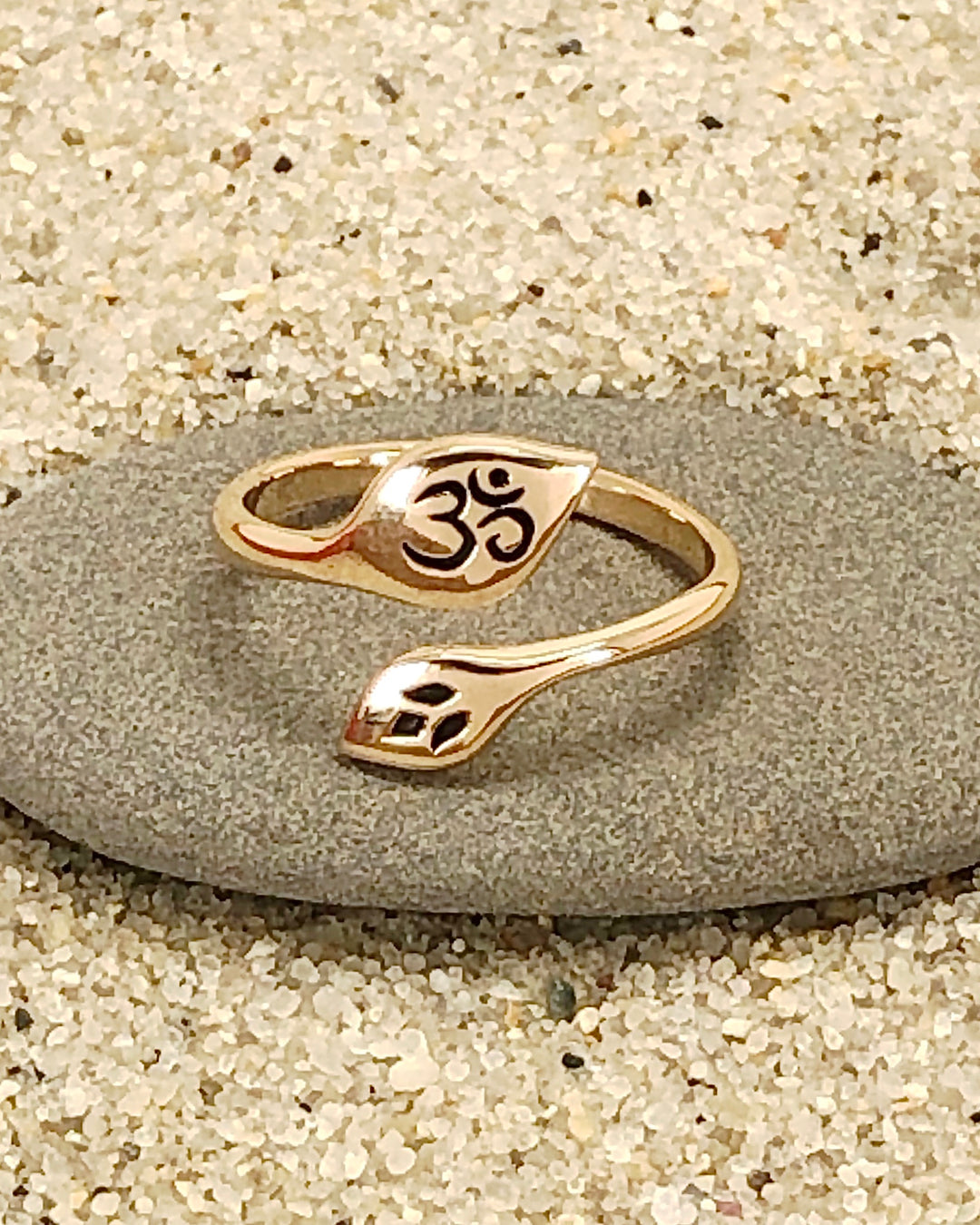 Om and Lotus Bronze Ring on stone with sand