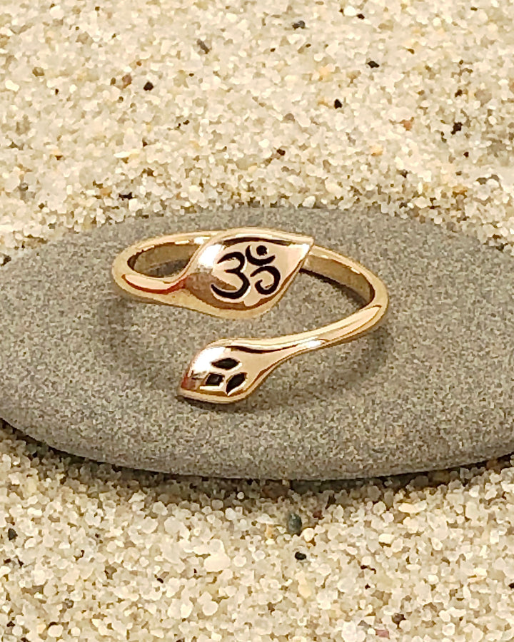 Om and Lotus Bronze Ring on stone with sand