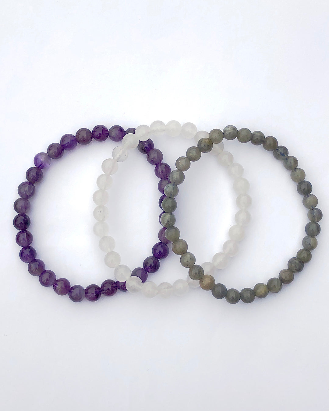 Amethyst, Snow Quartz and Labradorite 6mm beaded Gemstone Bracelet Set for Peaceful Transformation on a white background.