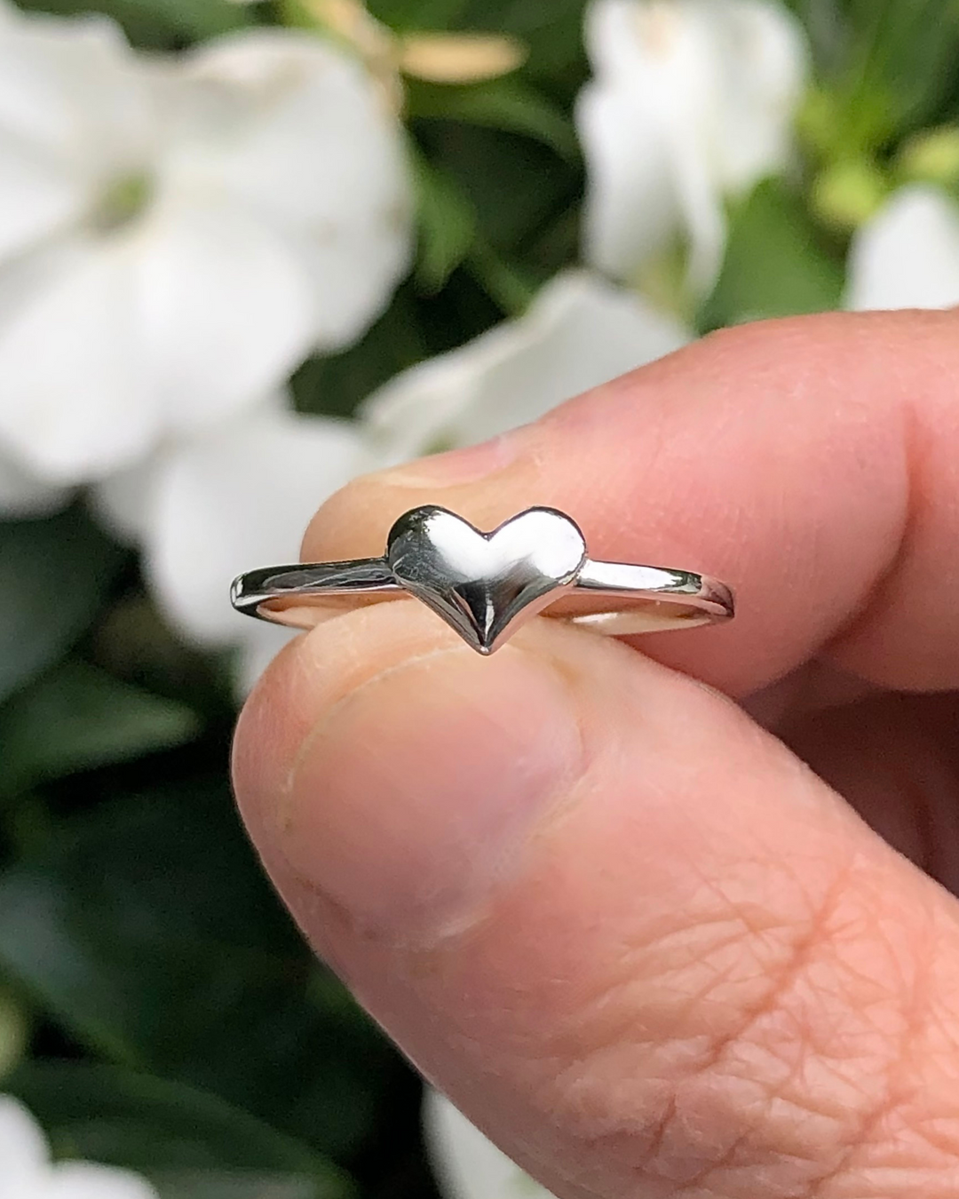 Sterling Silver Heart Ring between fingers close up
