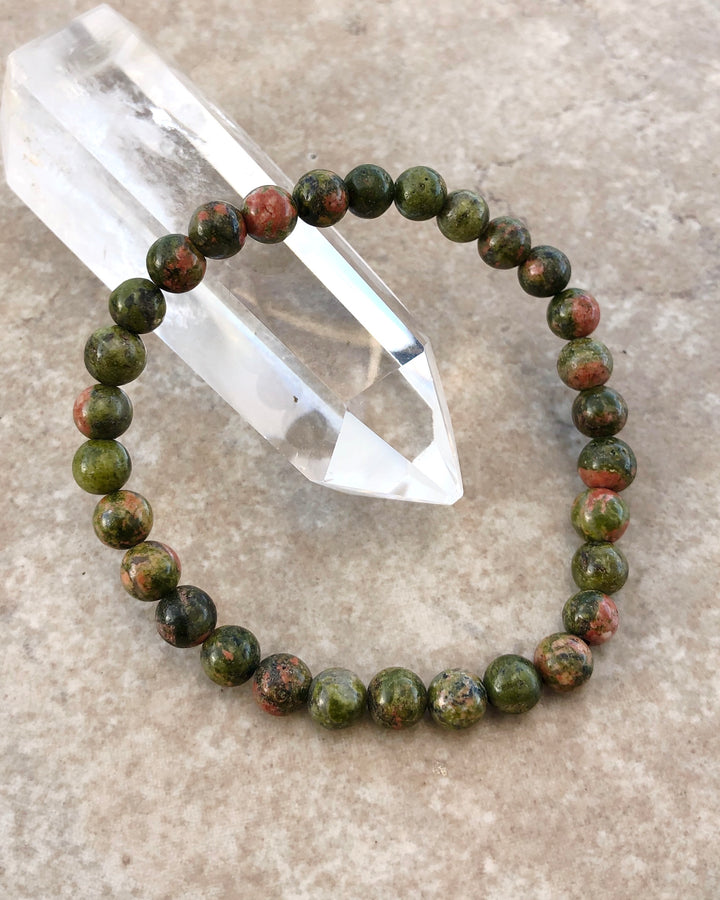 Unakite 6mm Beaded Gemstone Bracelet on a crystal.