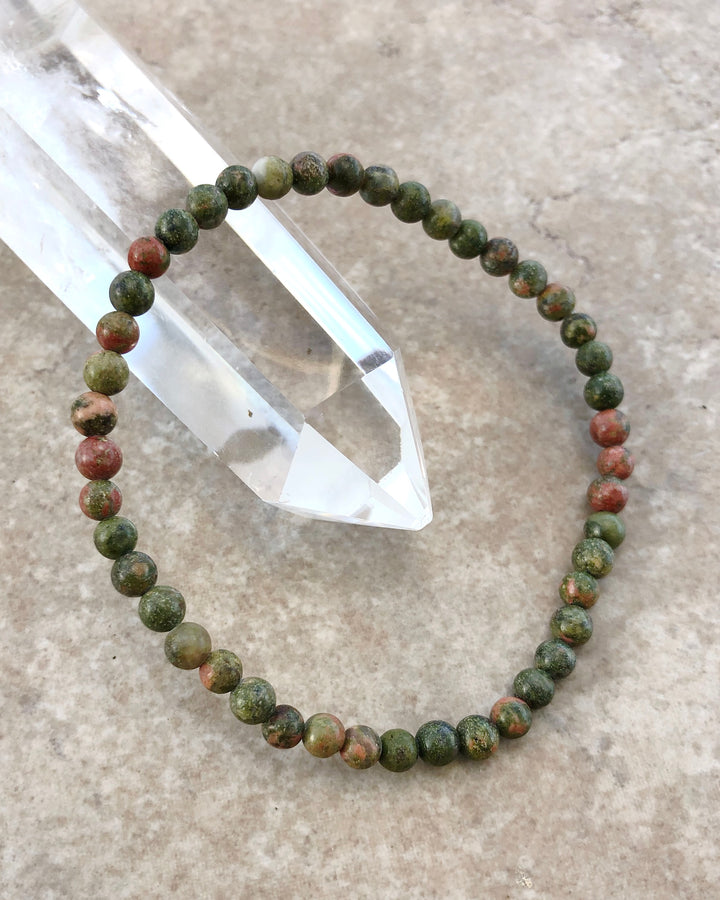 Unakite 4mm Beaded Gemstone Bracelet on a crystal.